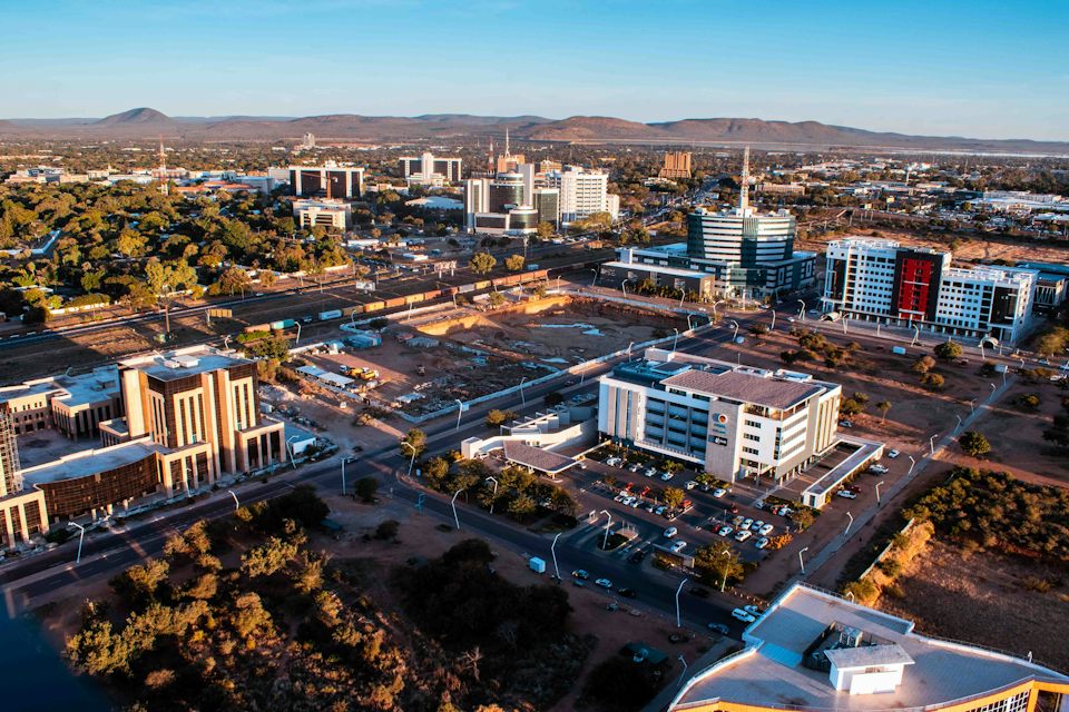 Aerial view of Gaborone's Central Business District at golden hour, with the hills beyond
